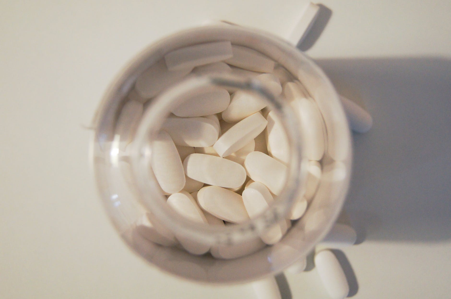 white medication pills in clear glass jar